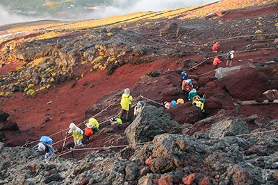 日の出直後に登山道を登っている写真