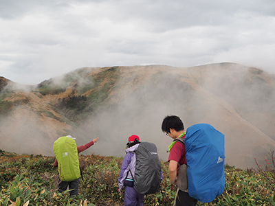 Ｉさんが撮影した巻機山山頂が見えて、山頂を指さしている写真