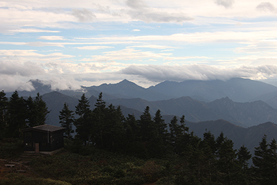 巻機山避難小屋と上越国境稜線の山々の写真