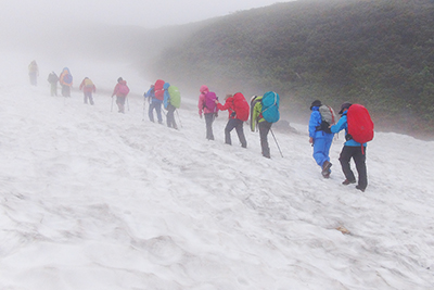 雪渓の上を登っているメンバーの写真