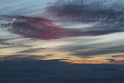 赤く色づいた夜明け前の雲の写真