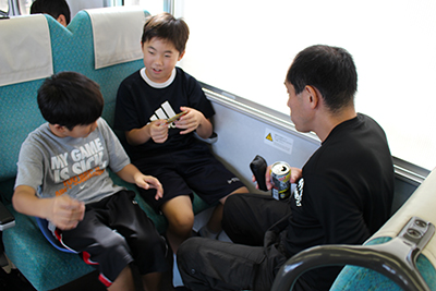 飯田線の車中でイスに座っている子どもたちとKさんの写真
