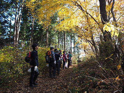 Iさんが撮影した黄色く紅葉した木に見入っているメンバーの写真