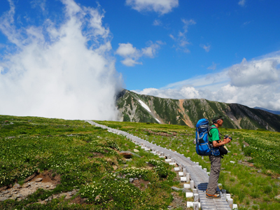 Iさんが撮影したチングルマの咲く五色ヶ原で写真を撮ろうとしているAさんの写真