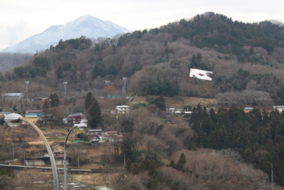 山腹にあるラブレターのモニュメントと左奥にある大室山の写真